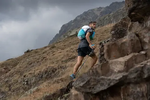 Coureur de trail en montée sur sentier avec fort dénivelé positif
