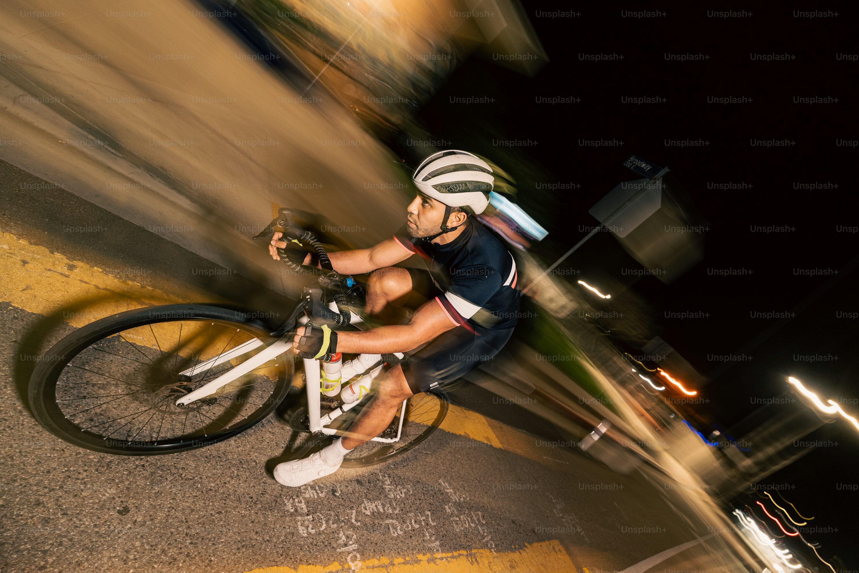 Cycliste roulant de nuit sur un ultra route avec éclairage et gilet réfléchissant