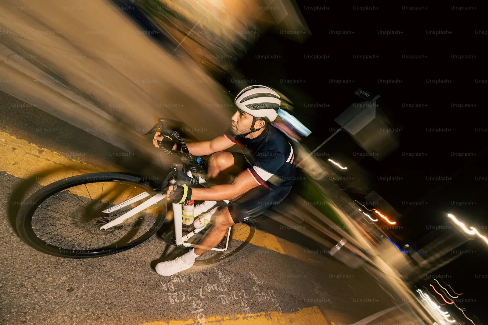 Cycliste roulant de nuit sur un ultra route avec éclairage et gilet réfléchissant